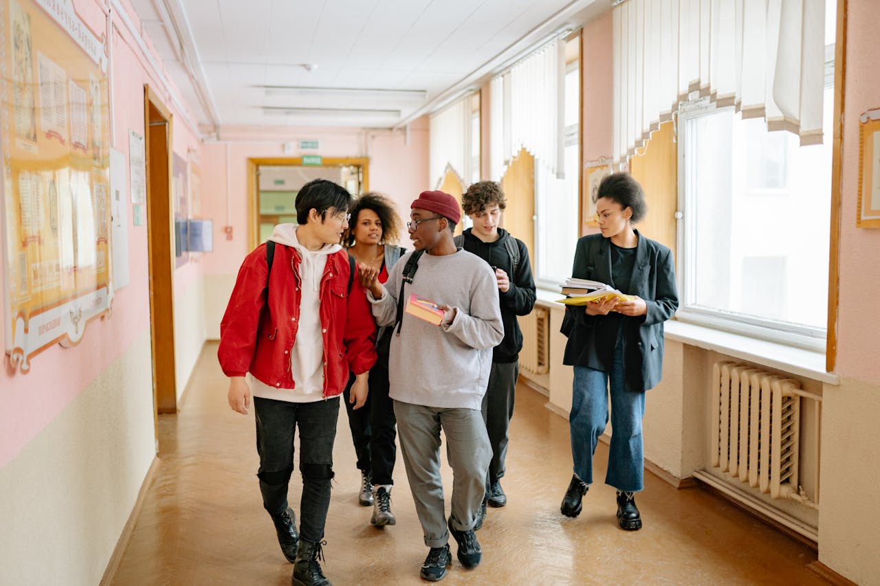 A diverse group of college students walking and conversing in a university hallway.